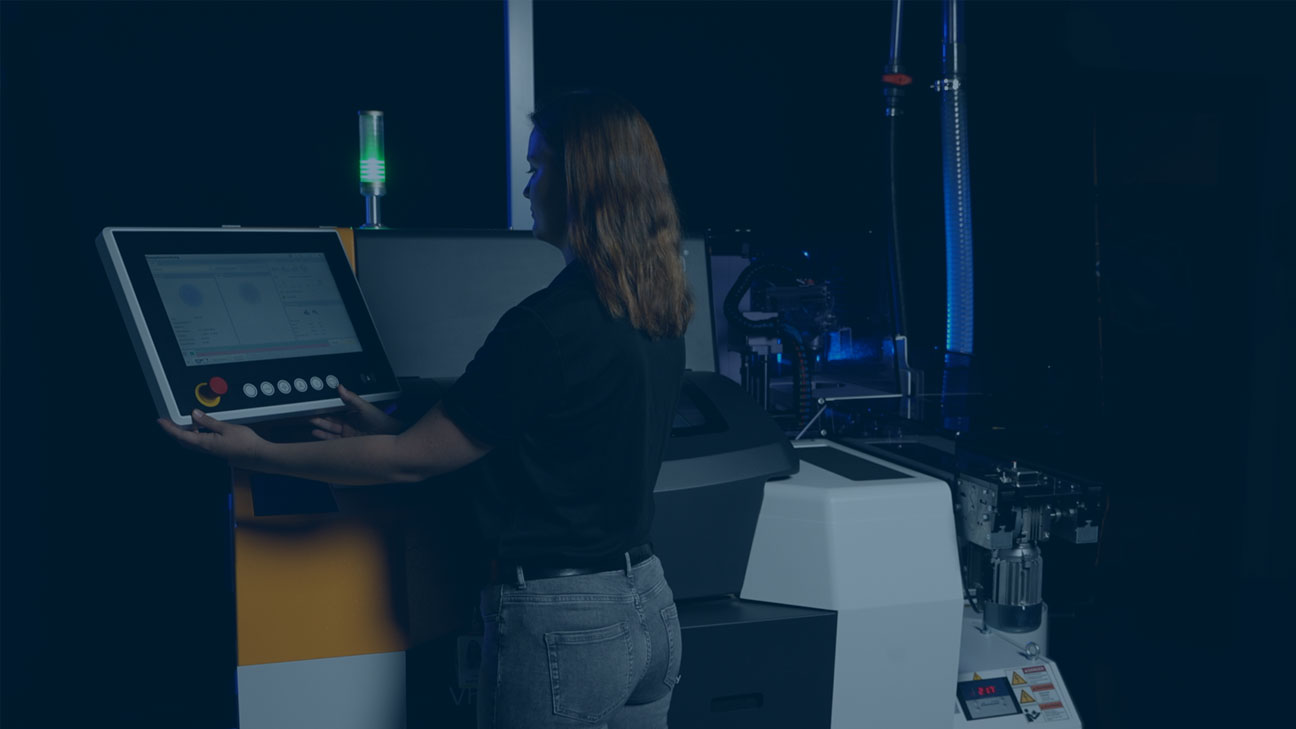 Technician operating an industrial machine using a touchscreen control panel.