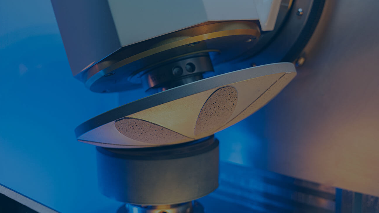 Laboratory machine with a conical tool in contact with a cylindrical test sample